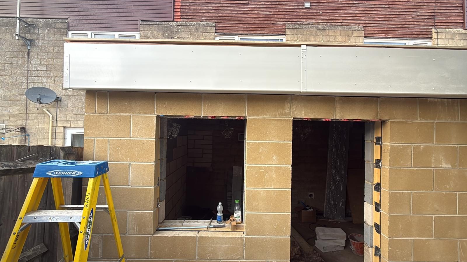During: blockwork walls with window and door openings and new fascia